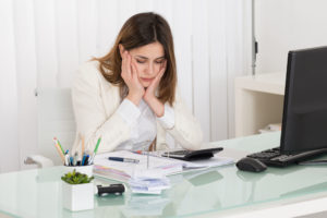 52625847 - young depressed businesswoman calculating invoice in office